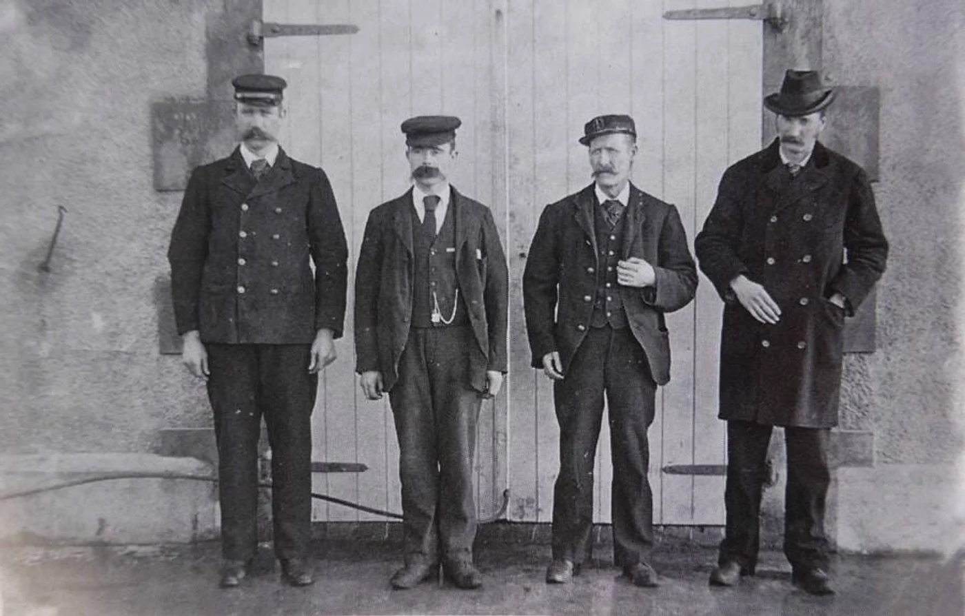 Foto: allthatsinteresting.com / Cei trei paznici ai farului care au dispărut, de la stânga la dreapta: Thomas Marshall, James Ducat și Donald MacArthur. Bărbatul din extrema dreaptă este Robert Muirhead, superintendentul Comisiei Farurilor, cel care i-a recrutat pe cei trei paznici dispăruți.